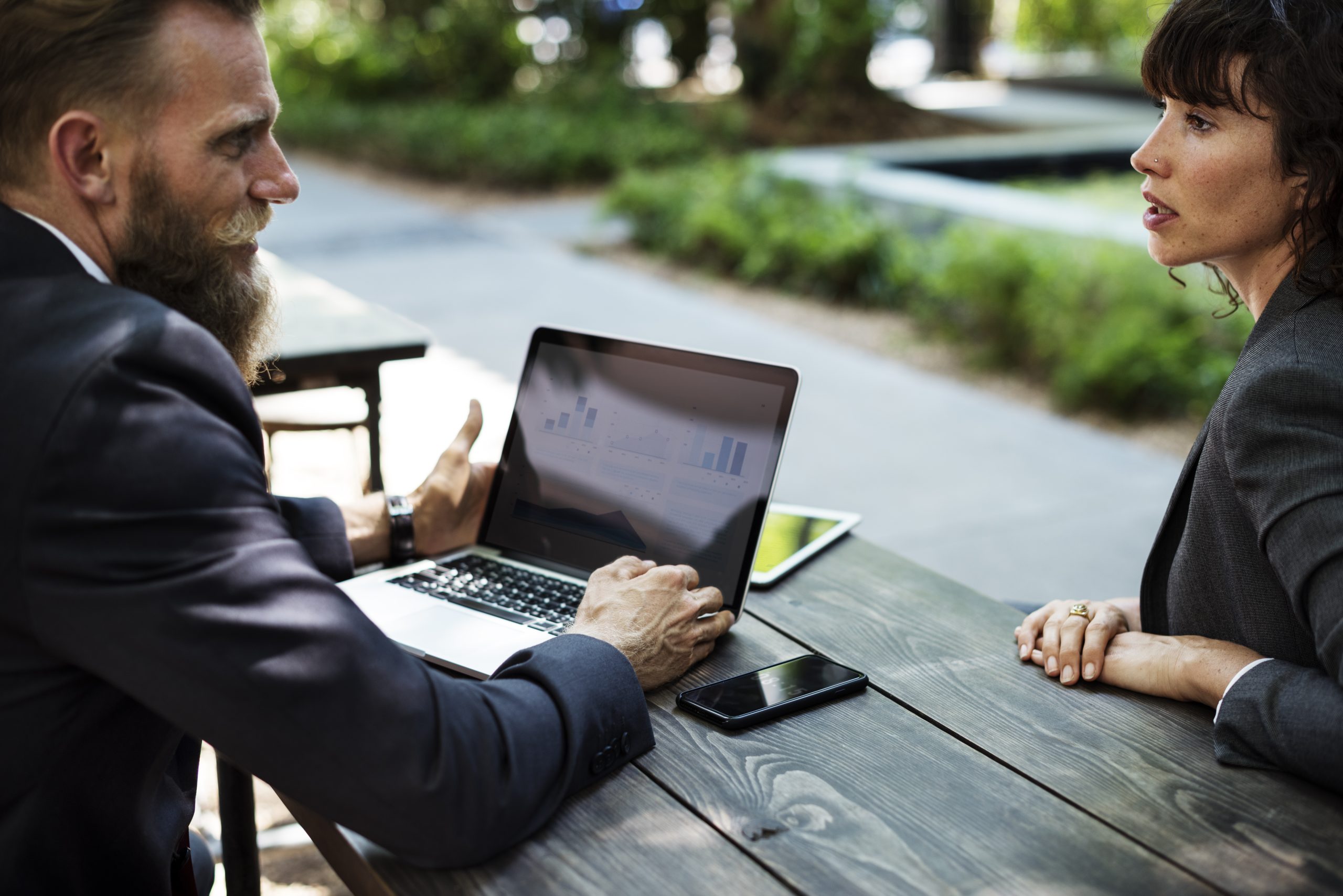 Professionals working on laptops outdoors