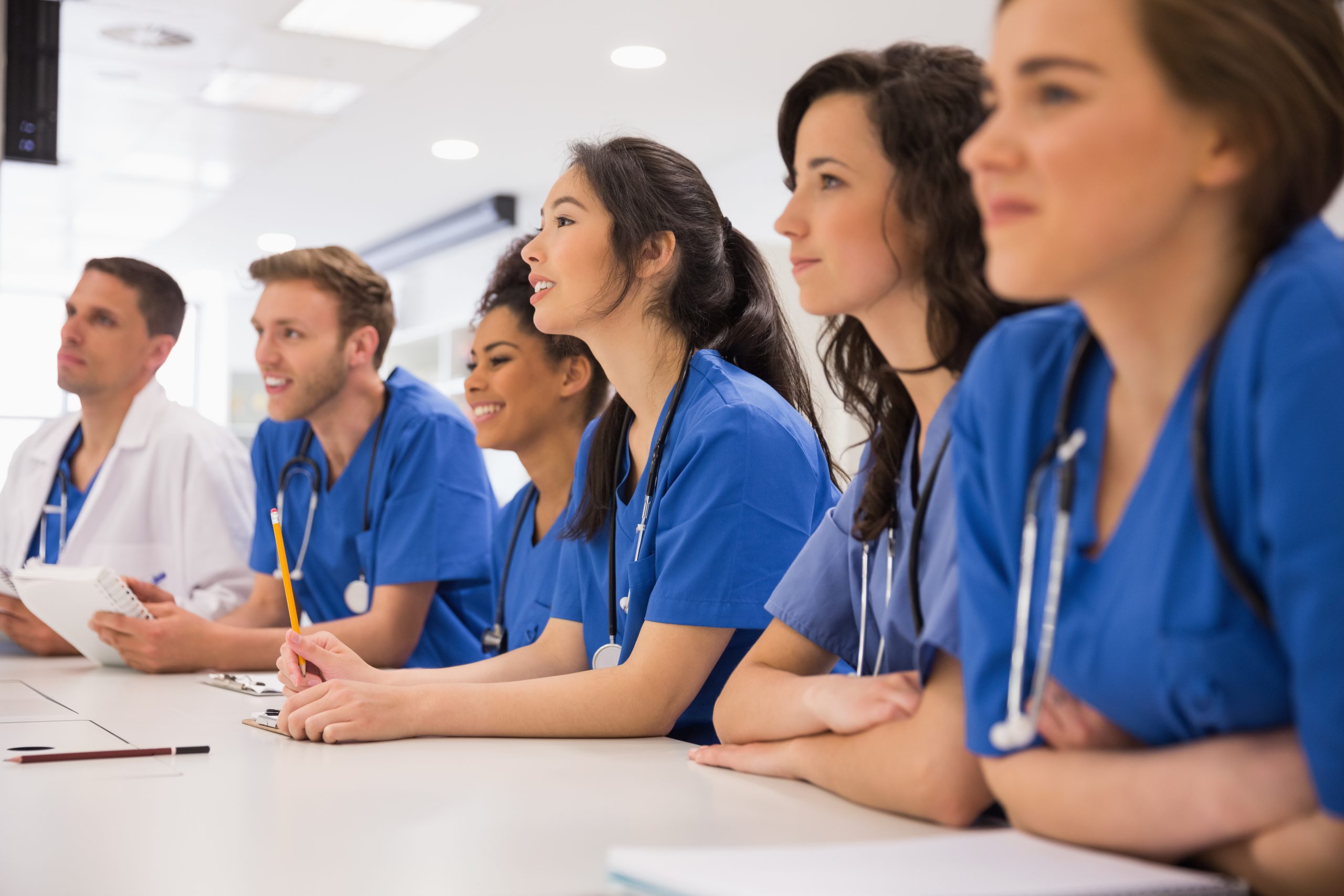 Team of healthcare workers in blue scrubs standing together