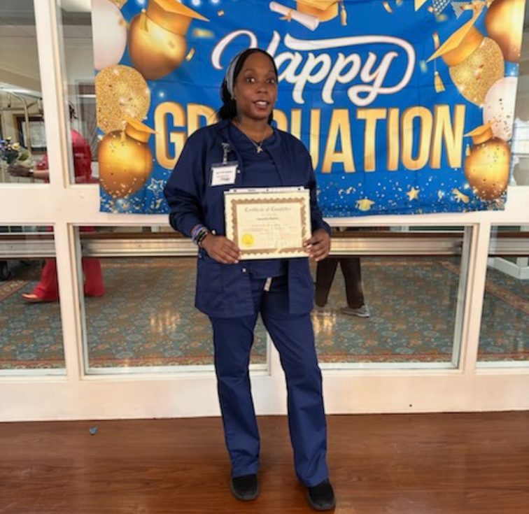 Employee holding certificate in front of store