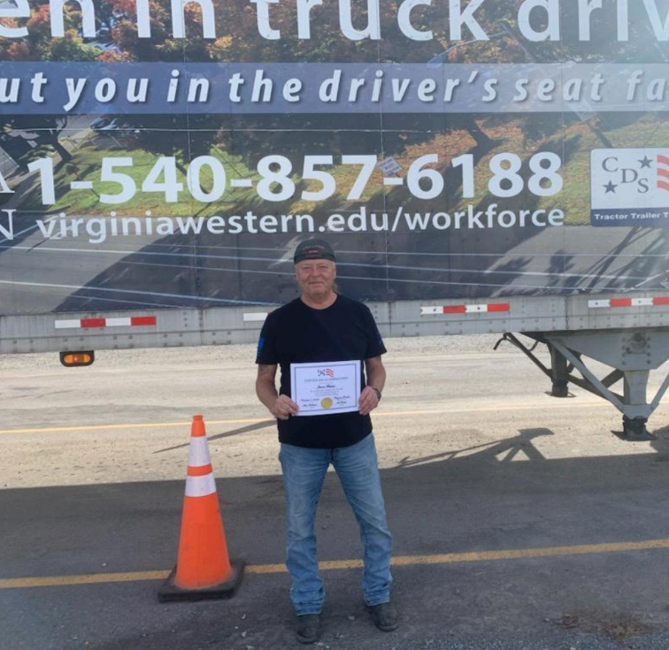 Worker standing near roadside with signage behind