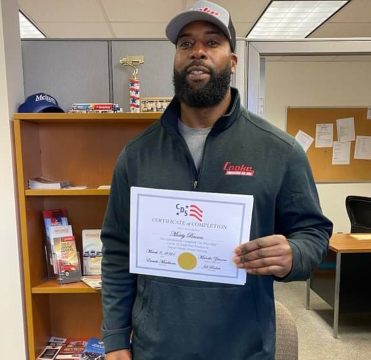 Man holding certificate in office setting