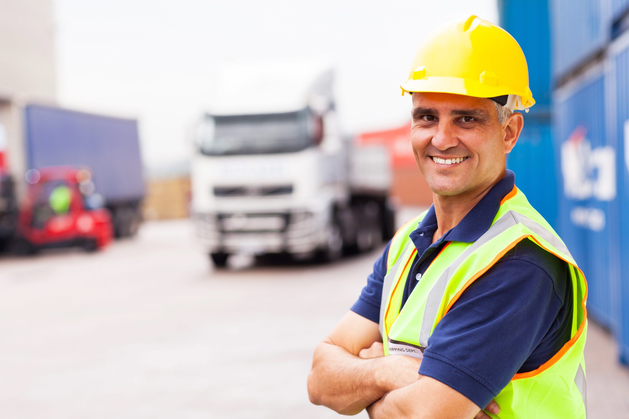Construction worker in safety gear smiling on site