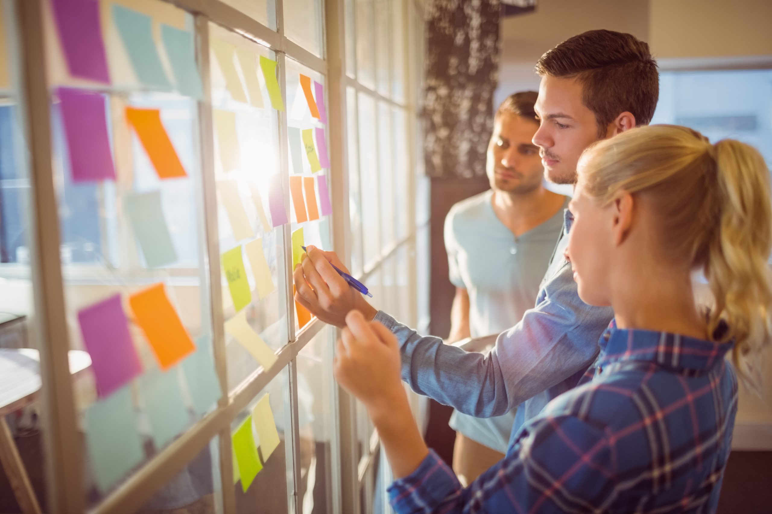 Group discussing ideas on glass board