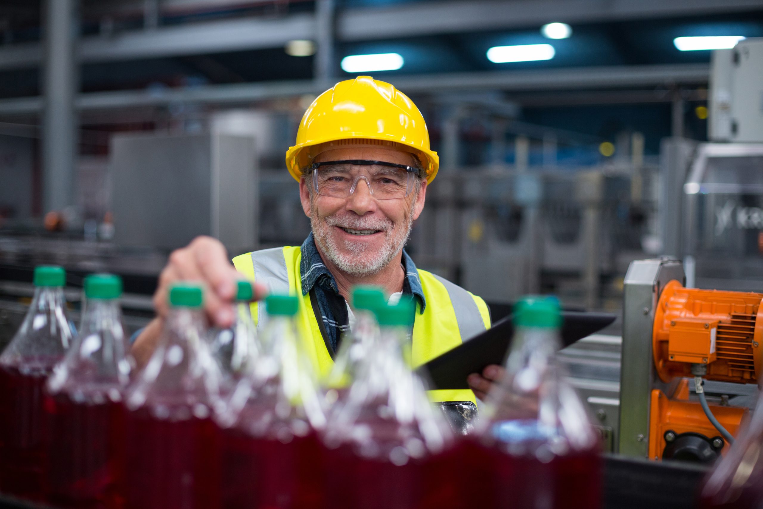 Worker holding bottles in factory