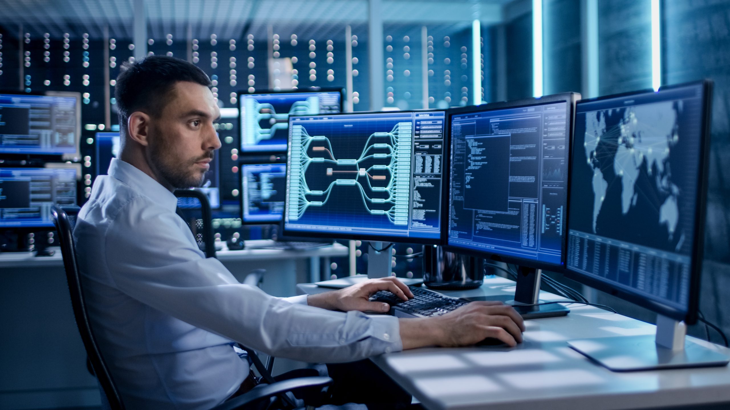 Analysts working at multi-screen computer station